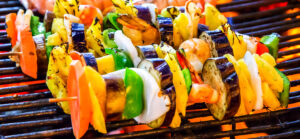 skewered vegetables on portable grill