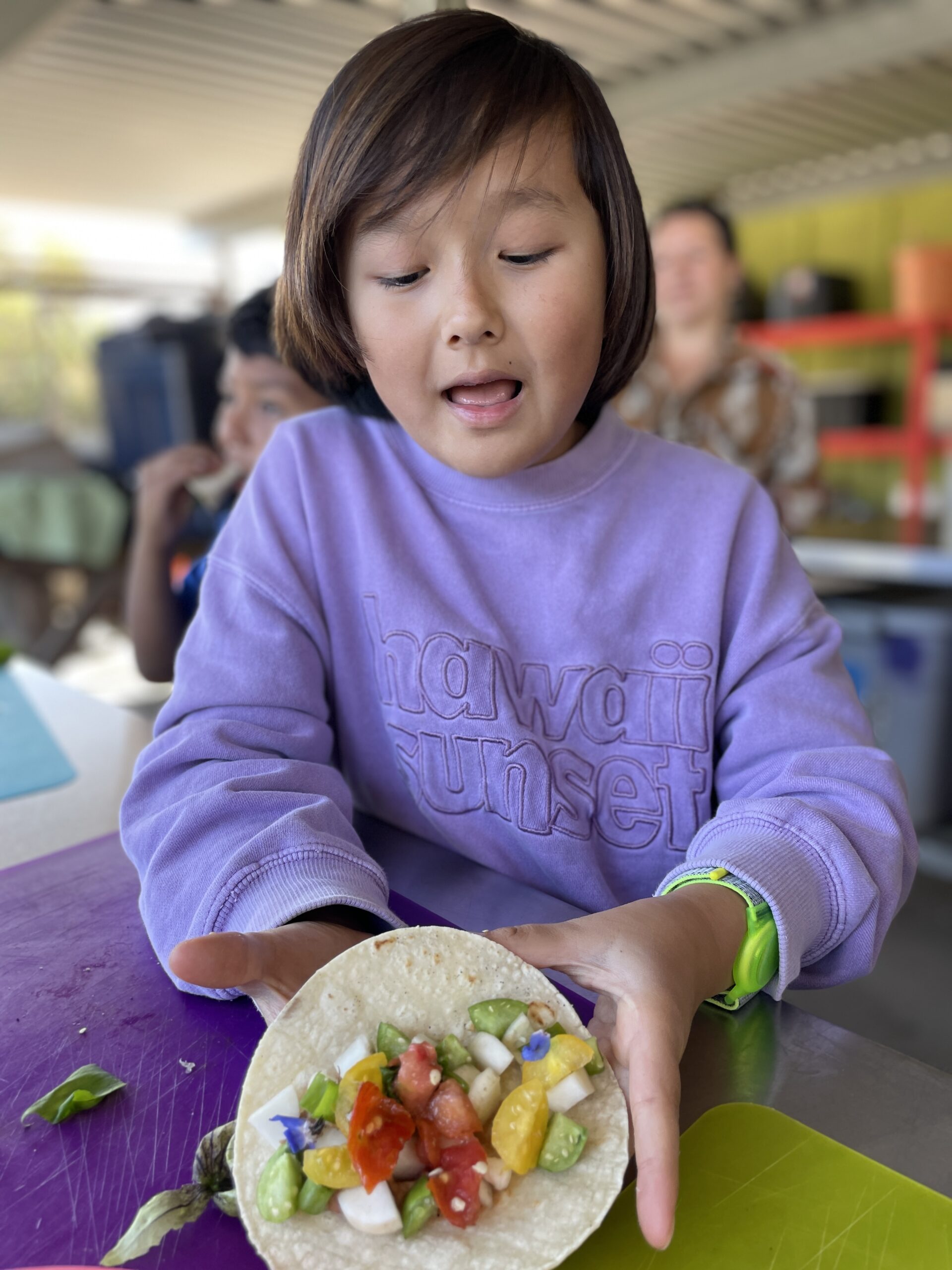 child eating taco made at HEAL project